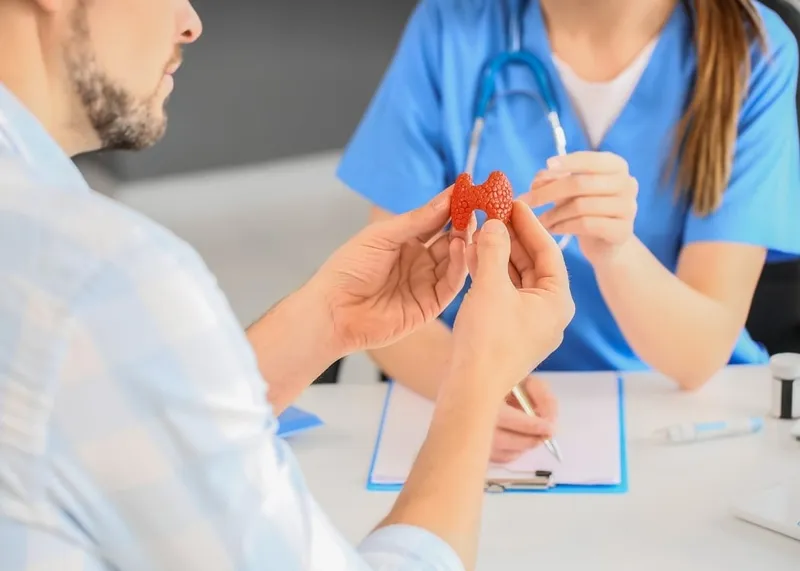 Endocrinologist explaining a written treatment plan to a patient during a consultation