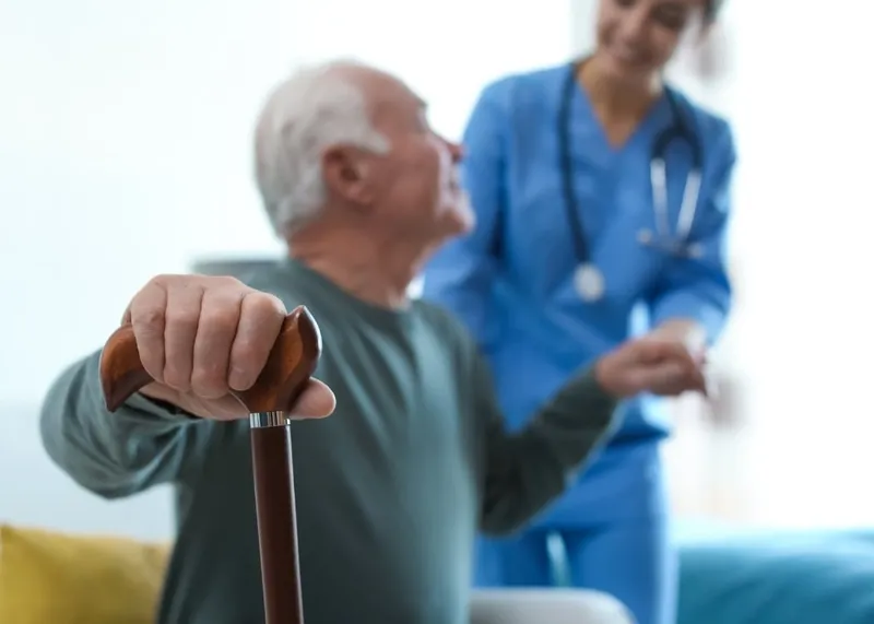 A caregiver holding hands with an elderly patient during a home care visit in Istanbul