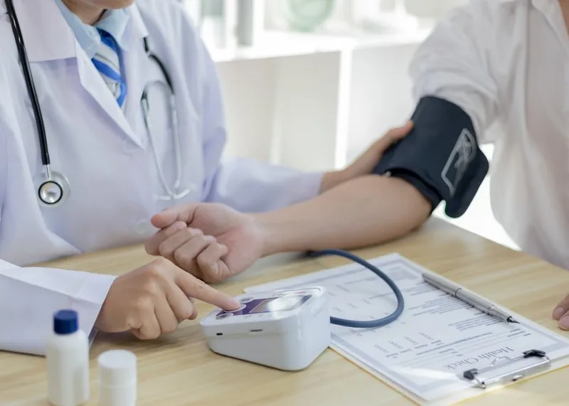 Doctor checking a patient's blood pressure during a follow-up visit