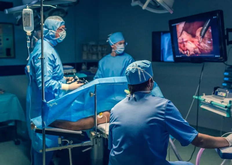 Surgeons performing a coronary bypass operation in a hospital operating room
