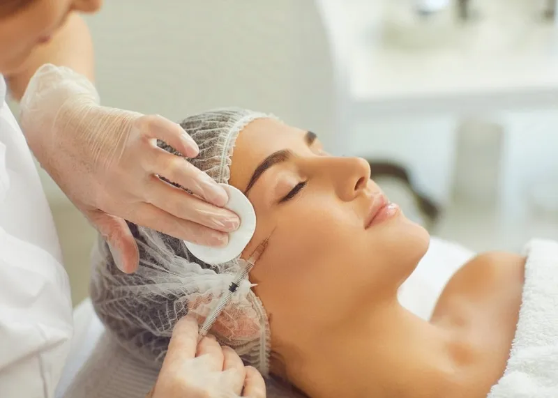 Dermatologist injecting Botox into a patient's forehead to reduce wrinkles