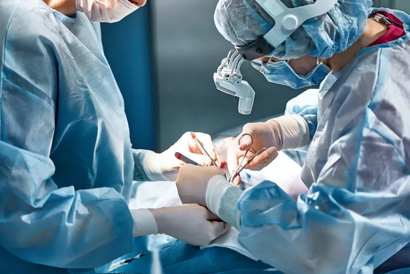 Surgical team performing a cosmetic plastic surgery procedure in a modern operating room