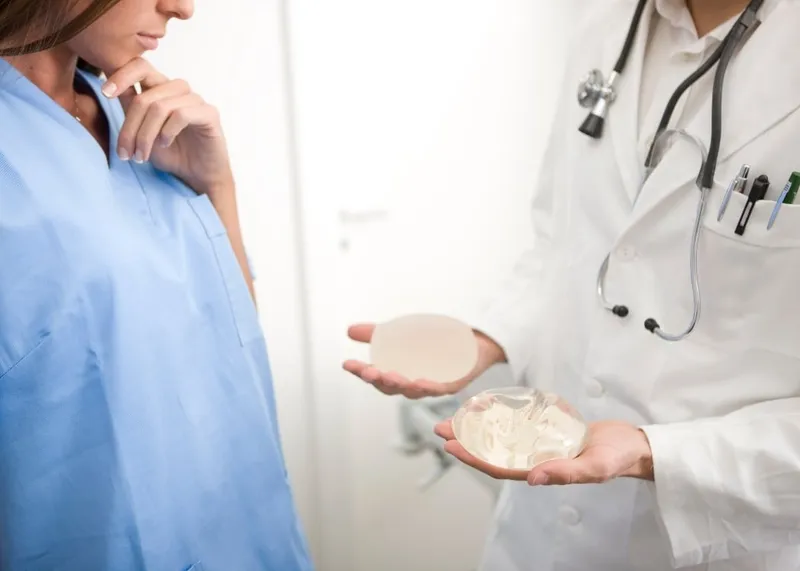 Nurse checking dressings at a follow-up visit after cosmetic surgery